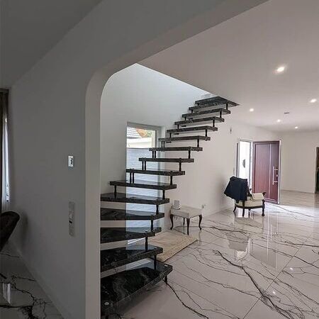 Freie Ecktreppe schwarz mit weißem Marmorboden